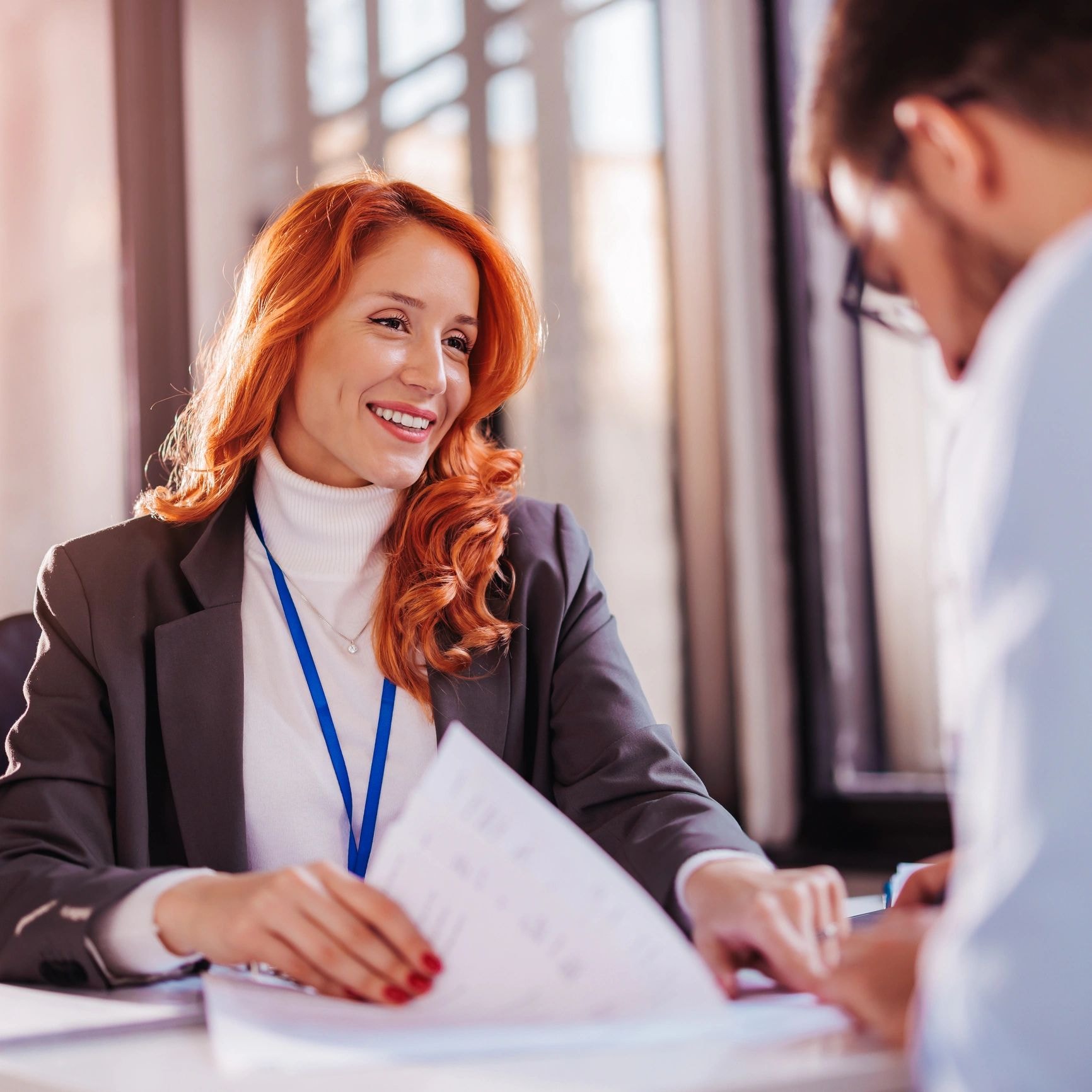 Attorney reviewing a document with a client across a desk in a bright office
